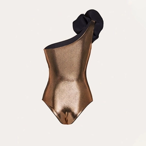 Metallic bronze one-shoulder swimsuit featuring black ruffled trim and shimmering fabric