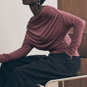 Chic burgundy off-shoulder long sleeve top with ruching paired with black trousers