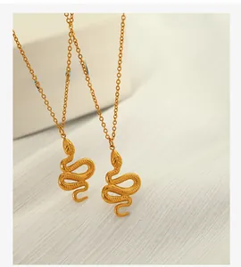 Macro shot of gold snake pendants showing detailed scales and fine chain texture