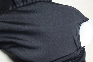 Gros plan sur le tissu en maille noire avec coutures de qualité et rembourrage de poitrine
