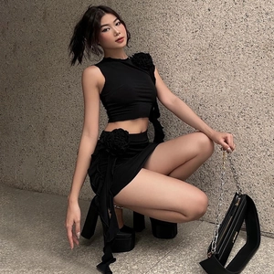 Detailed view of 3D rose accent on a chic black sleeveless top and matching mini skirt