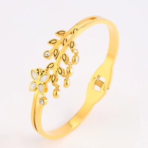 Detail of gold butterfly bracelet showing leaf design with zircon and hinge closure