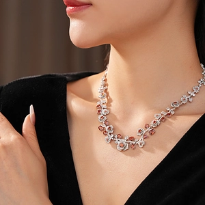 Close-up of vintage rose necklace with red gems and white diamonds on a model
