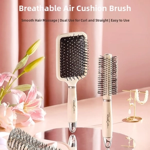 Close-up of cream paddle brush and round hairbrush with massage bristles and silver accents