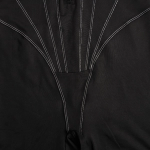 Détail d'un body noir en tricot avec des coutures blanches contrastées et un tissu extensible