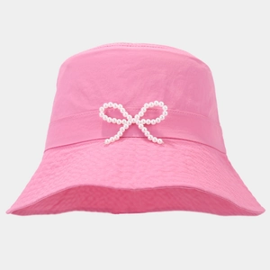 Detailed view of pink bucket hat with pearly bow decoration and reinforced stitching