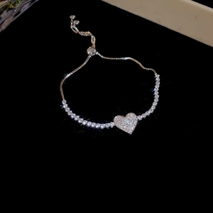 Detail of a sparkling heart charm bracelet with adjustable slider clasp in silver finish