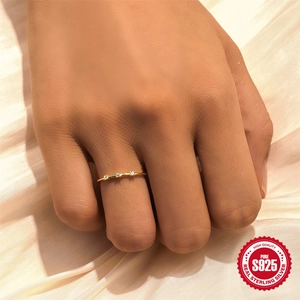 Minimalist S925 sterling silver gold ring with three teardrop zirconia on silk backdrop