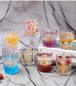Artistic detail of aromatherapy gel candles with dried flowers and gold foil in glass