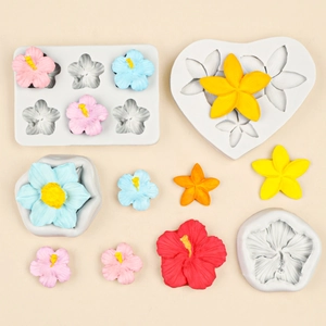 White silicone frangipani flower molds with colorful resin floral creations on beige base