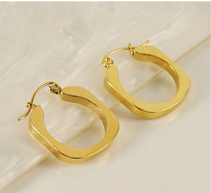 Detailed close-up of chunky gold-plated stainless steel U-shaped hoop earrings with polished finish
