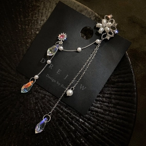 Vue détaillée des boucles d'oreilles papillon à pompons avec perles et zircons