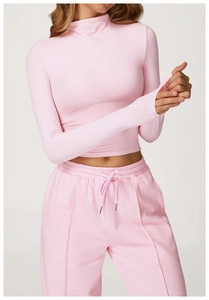 Close-up of pink high-neck crop top with thumbholes and drawstring sports pants