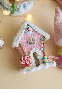 Close-up of a pink gingerbread house Christmas ornament with glitter and snowy texture