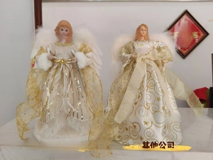 Detailed view of two Christmas tree topper angels with golden lace dresses and white wings