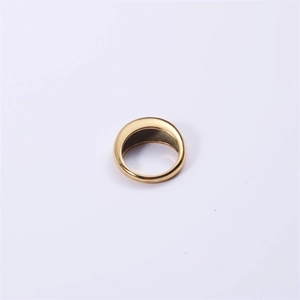 Close-up of a wide polished gold stainless steel ring with a smooth reflective surface