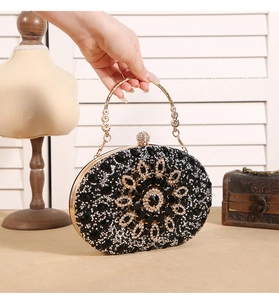Detail of black sunflower evening bag with crystals and a gold ring handle