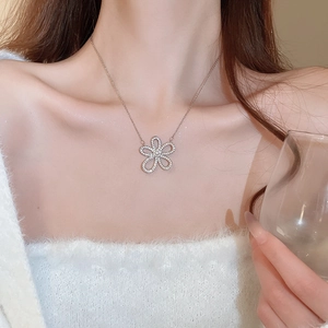 Close-up of sparkling floral pendant necklace worn by a model with a cozy aesthetic