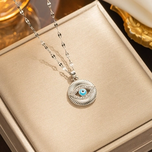 Detailed close-up of blue evil eye necklace on a luxurious golden jewelry box