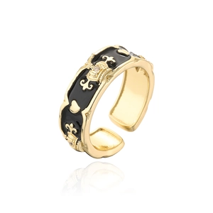 Close-up of 18K gold-plated crown ring with black enamel details and zircon accents