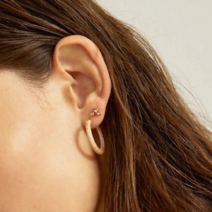Gold hoop earrings and bee stud set with purple zircons worn by model for fashion styling