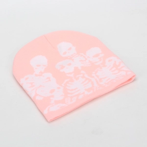 Close-up of pink knit beanie featuring detailed white skull skeleton embroidery design
