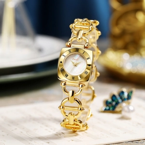 Macro detail of a golden vintage watch with a mother of pearl dial and chain bracelet