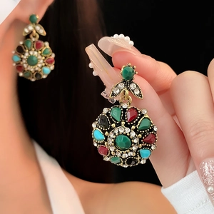 Detailed close-up of vintage floral earrings with colorful crystals and gold metal finish