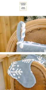 Detail der blauen Plüsch-Weihnachtssocke mit weißem Schneeflockenmuster und Aufhänger
