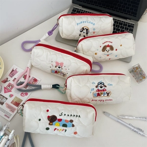 Detailed view of white quilted pencil cases with cute embroidered puppy designs