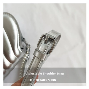 Detail of silver shell bag showing adjustable shoulder strap with metal buckle and pearls