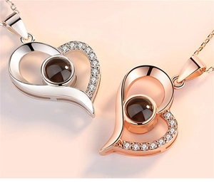 Detail of silver and rose gold heart pendants with shimmering pavé diamonds and projection stone