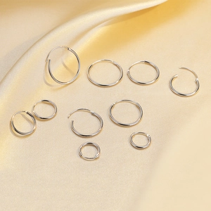 Minimalist S925 sterling silver hoop earrings set displayed on champagne silk fabric