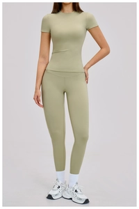 Detailed view of women's high-waist yoga pants and compression shirt in sage green fabric