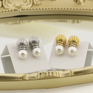 Close-up of vintage pearl earrings in gold and silver finish with rhinestone accents