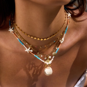 Layered gold necklace with sea shells, starfish charms and colorful beads for beach style