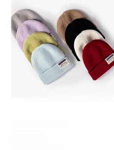 Detailed view of rib-knit beanie textures and decorative fabric labels in eight colors