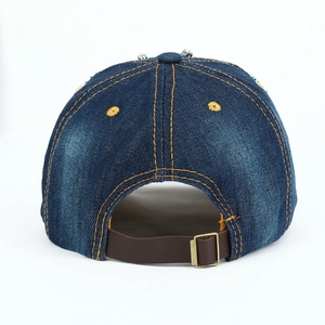 Détail d'une casquette en jean avec lanière en cuir et boucle en cuivre rétro