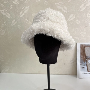 Detailed view of white faux fur bucket hat with soft plush textured curly fleece fabric