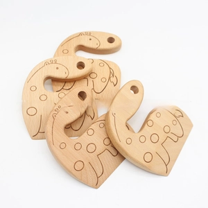 Close-up of four giraffe-shaped beech wood toy knives with laser engraved patterns