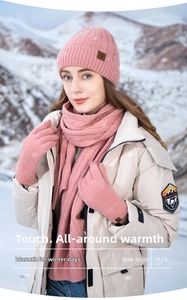 Pink winter knit set featuring a beanie, long scarf, and gloves against a snowy mountain