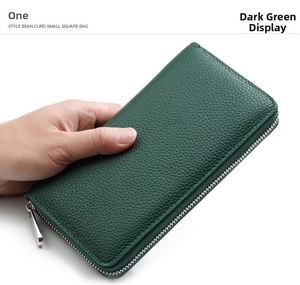 Detail of dark green leather wallet with litchi texture and metal zipper closure