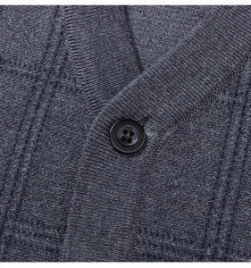 Close-up of V-neckline and button detail on dark grey knit vest for men