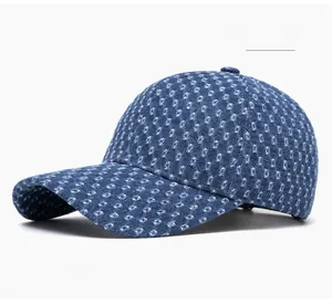 Close-up of blue denim baseball cap showing white geometric jacquard and distressed details