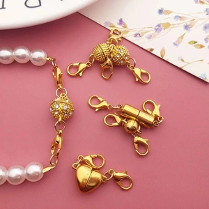 Golden magnetic jewelry clasps set with lobster claws in heart and sphere shapes