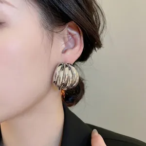 Minimalist silver multi-layer spiral earrings featuring a bold metallic geometric design