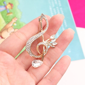 Close-up of a musical note brooch with sparkling rhinestones and a teardrop crystal