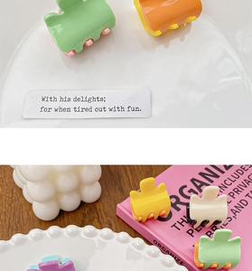 Close-up of candy-colored mini hair claws in vibrant pastel tones on a decorative plate