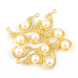 Vue macro de pendentifs en alliage doré avec perles blanches et strass étincelants