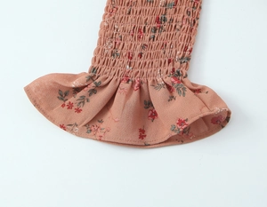 Détail de poignet élastique froncé avec imprimé fleuri et bord à volants sur blouse